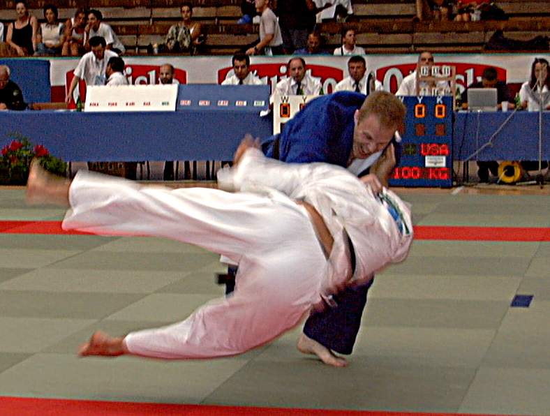 Judoka executing a throwing technique during judo competition